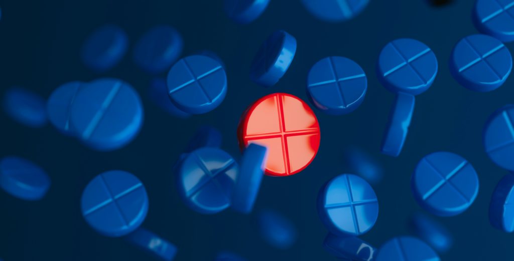 red tablet surrounded by blue tablets