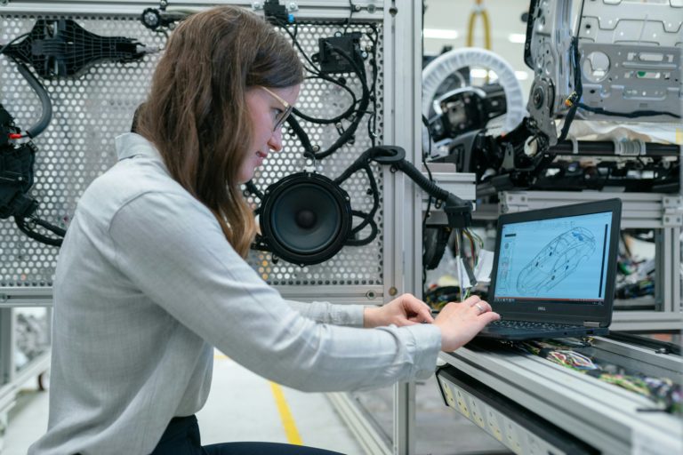 Femme utilisant un ordinateur portable pour la surveillance des machines industrielles